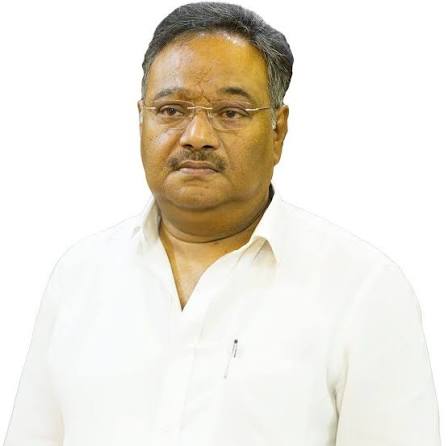 Formal portrait of Samik Bhattacharya in a white shirt against a plain white background